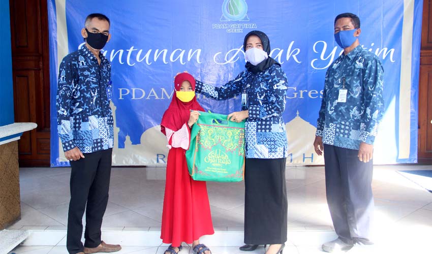 Direktur Utama PDAM Giri Tirta Gresik, Siti Aminatus Zariyah saat memyerahkan bingkisan lebaran dan uang saku kepada anak yatim